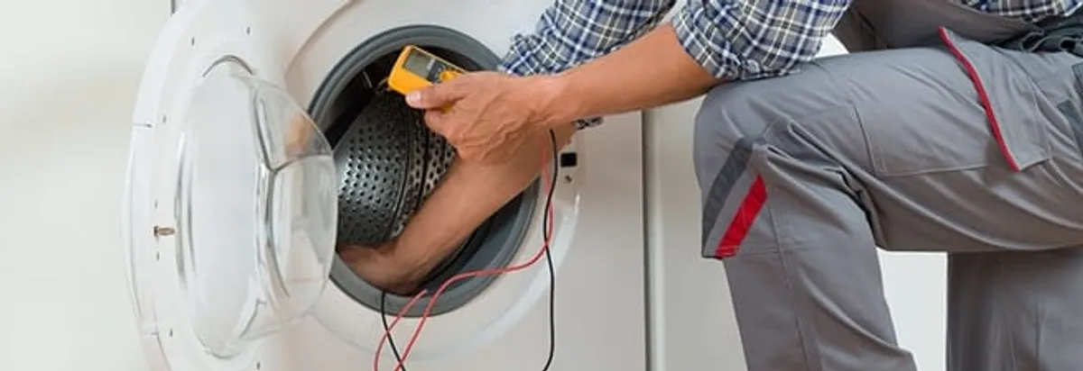 Dryer repair technician inspecting and repairing a clothes dryer in Tallahassee, FL