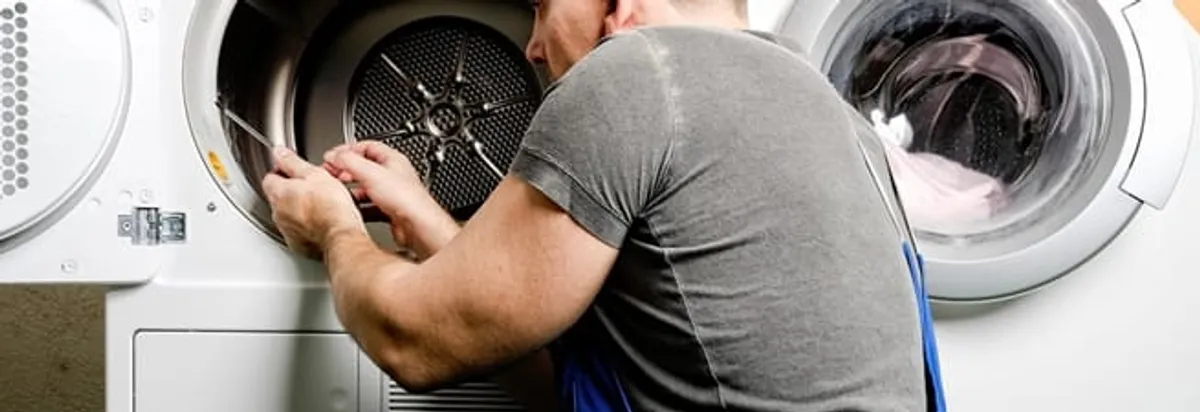 Dryer repair technician fixing a clothes dryer drum in Tallahassee, FL
