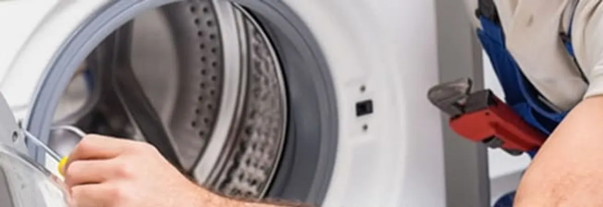 Appliance technician repairing a clothes dryer drum and internal parts in Tallahassee, FL
