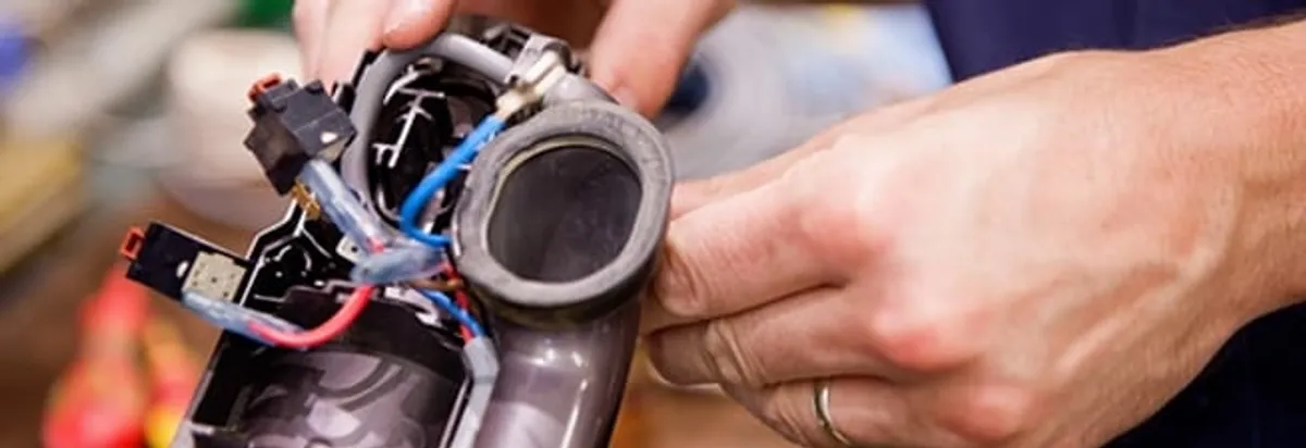 Vacuum repair technician reconnecting wiring and components in Tallahassee, FL
