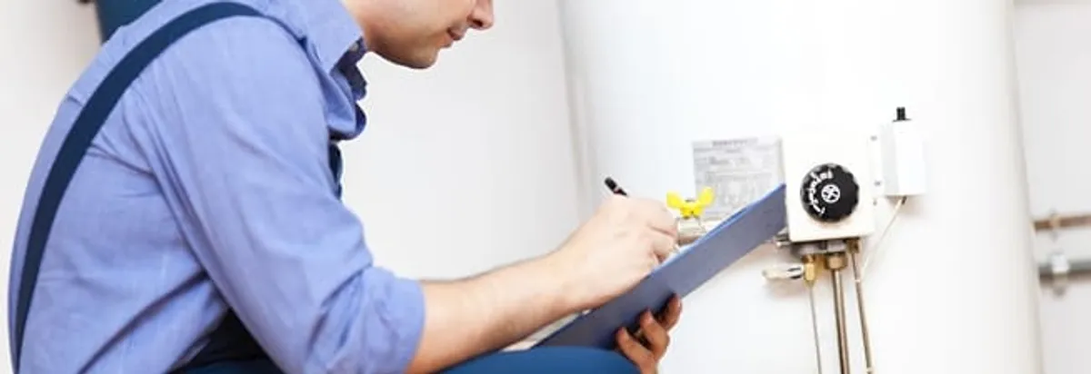 Water heater repair technician inspecting the unit and recording service notes in Tallahassee, FL