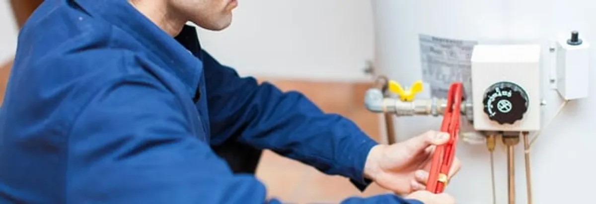 Water heater repair technician adjusting the temperature control and gas valve in Tallahassee, FL